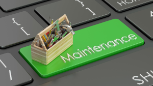 A keyboard with a green 'Maintenance' key and a toolbox, symbolizing the importance of scheduling a proactive A/C tune-up with Fast Air Conditioning Repair.