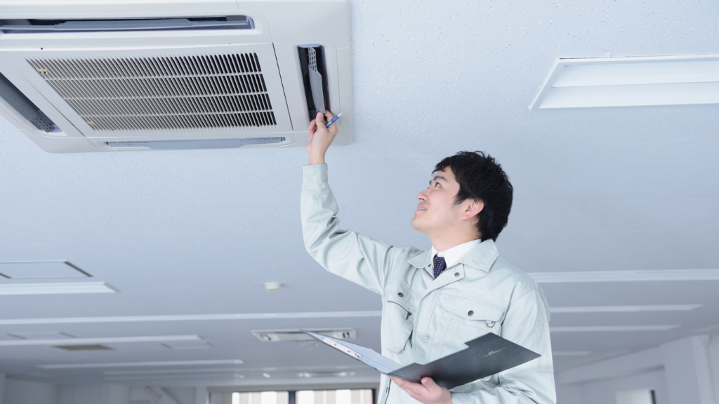 A certified technician from Fast Air Conditioning Repair performs a professional A/C maintenance tune-up and inspection on a ceiling unit.