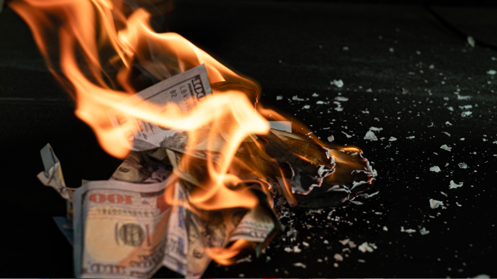 Burning one hundred dollar bills, symbolizing the wasted money of repeatedly topping off a leaking A/C unit instead of fixing the leak.